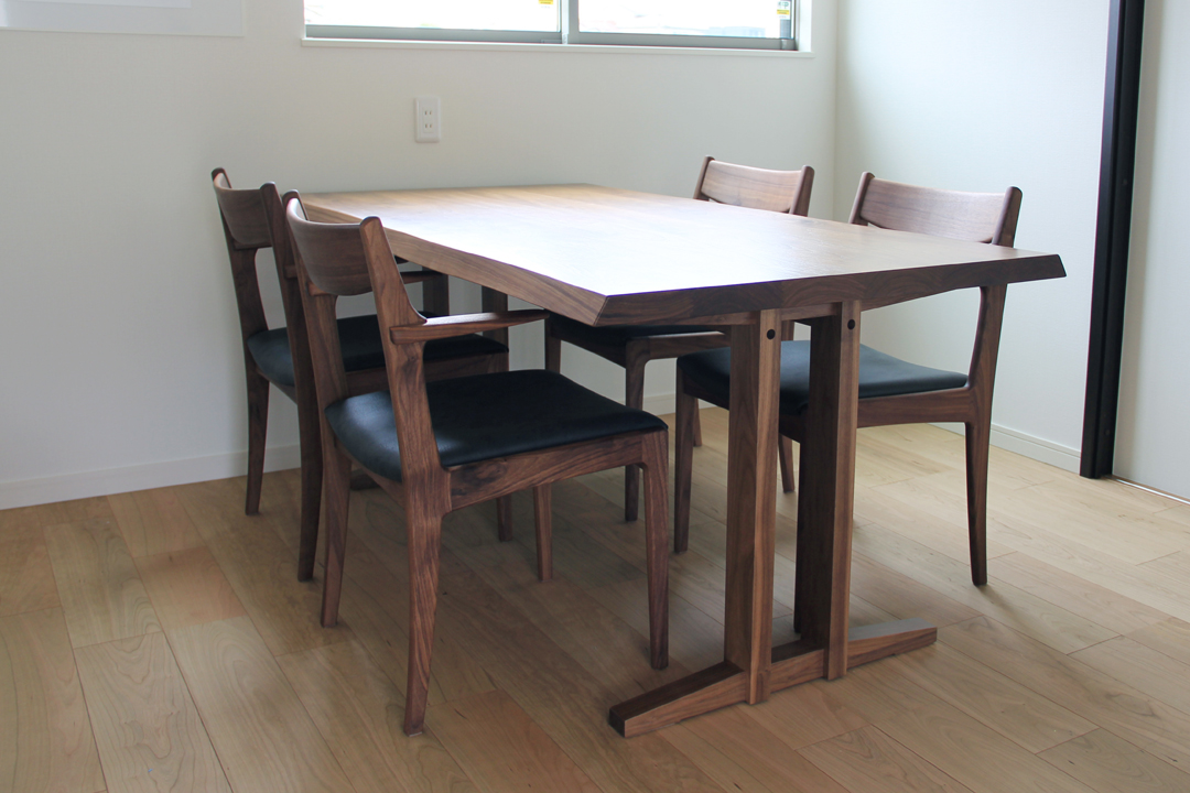 シンプルな2本脚構造のテーブルと愛らしい肘形状のチェア